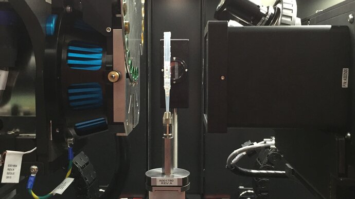 Inside the Zeiss micro-CT showing specimens being scanned within a rotating column (centre), located between the X-ray source (left) and detector (right).